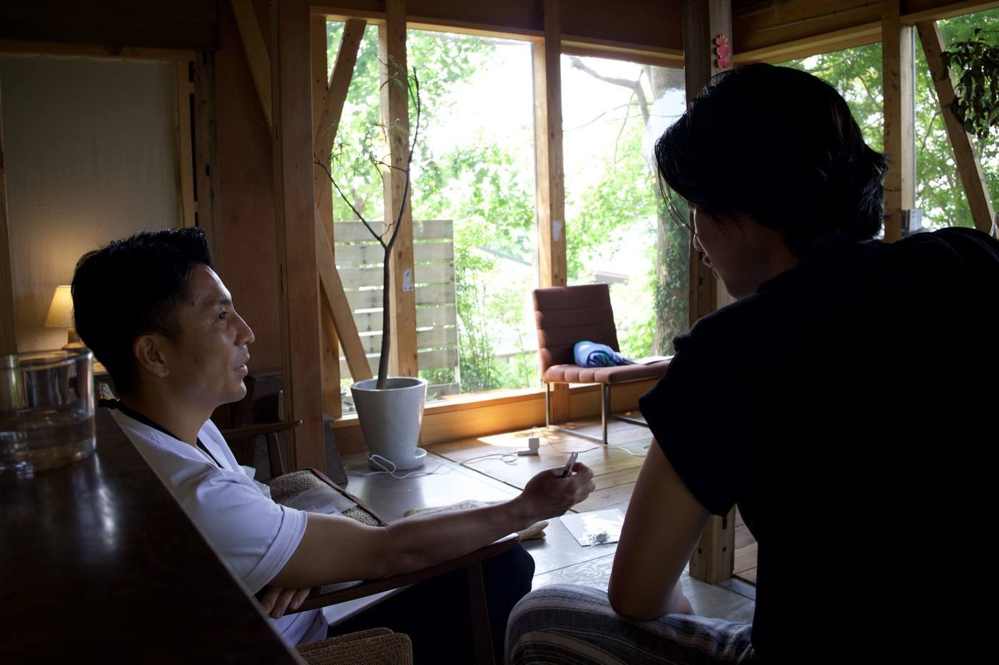 光が差す室内で向かい合って対話する二人